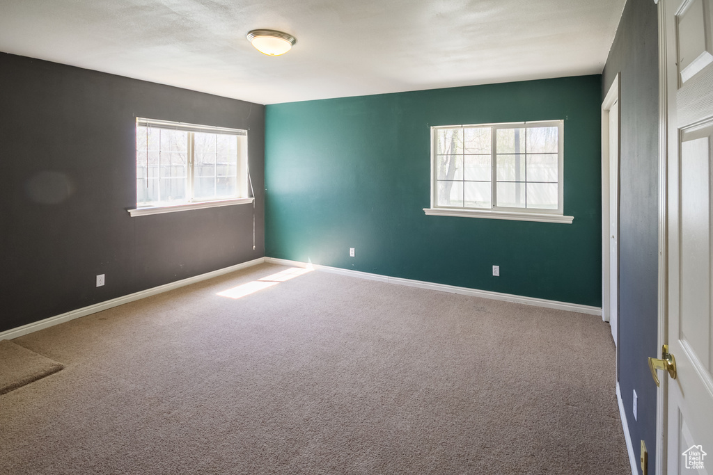 Carpeted spare room with baseboards