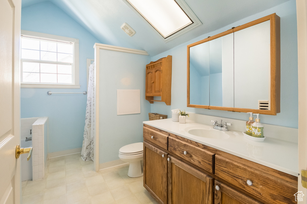Full bathroom featuring a shower with shower curtain, vanity, toilet, visible vents, and lofted ceiling