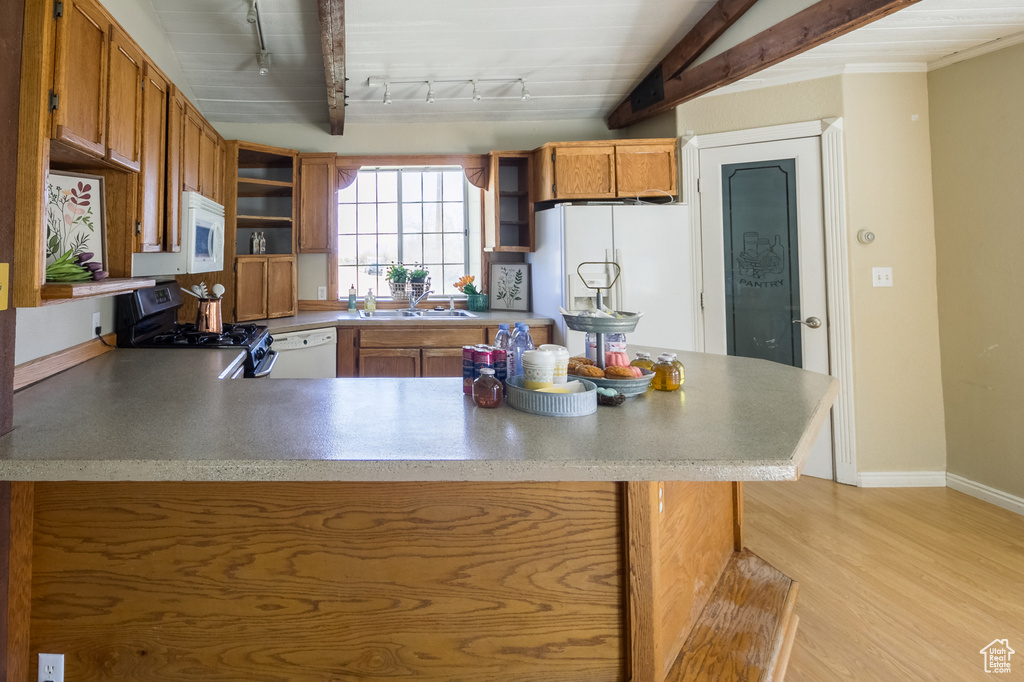 Kitchen with open shelves, a sink, white appliances, a peninsula, and rail lighting