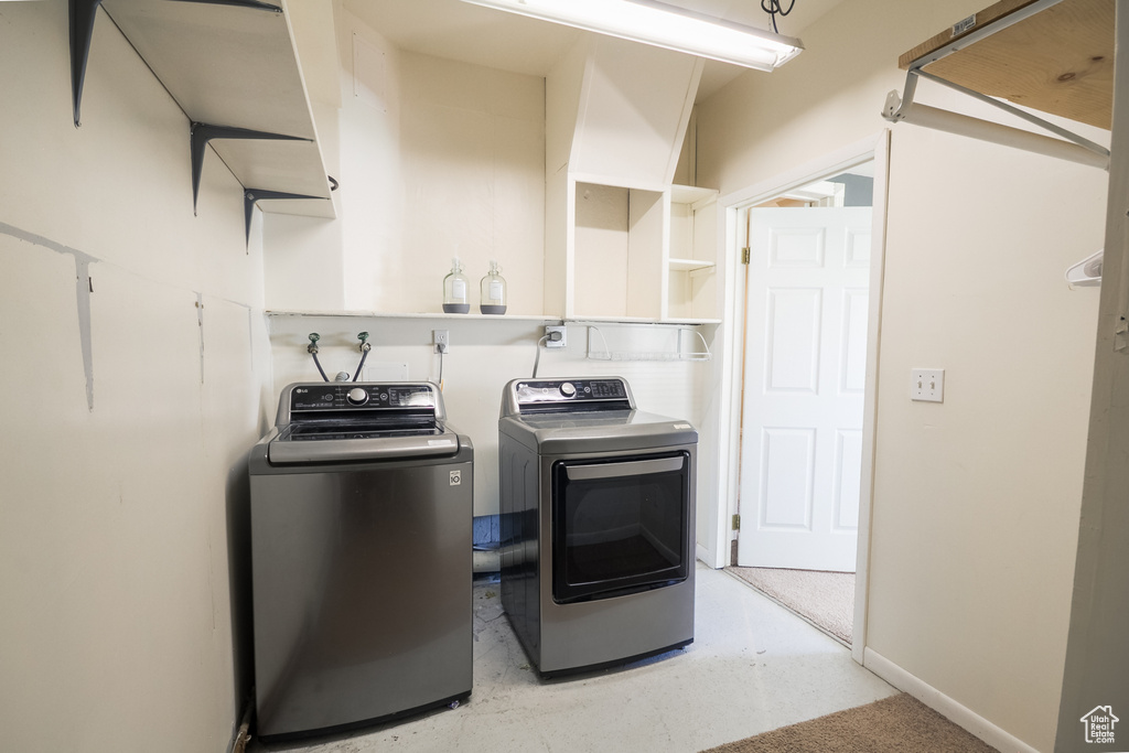 Laundry area featuring independent washer and dryer, laundry area, baseboards, and light floors