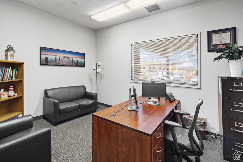 Carpeted home office featuring baseboards