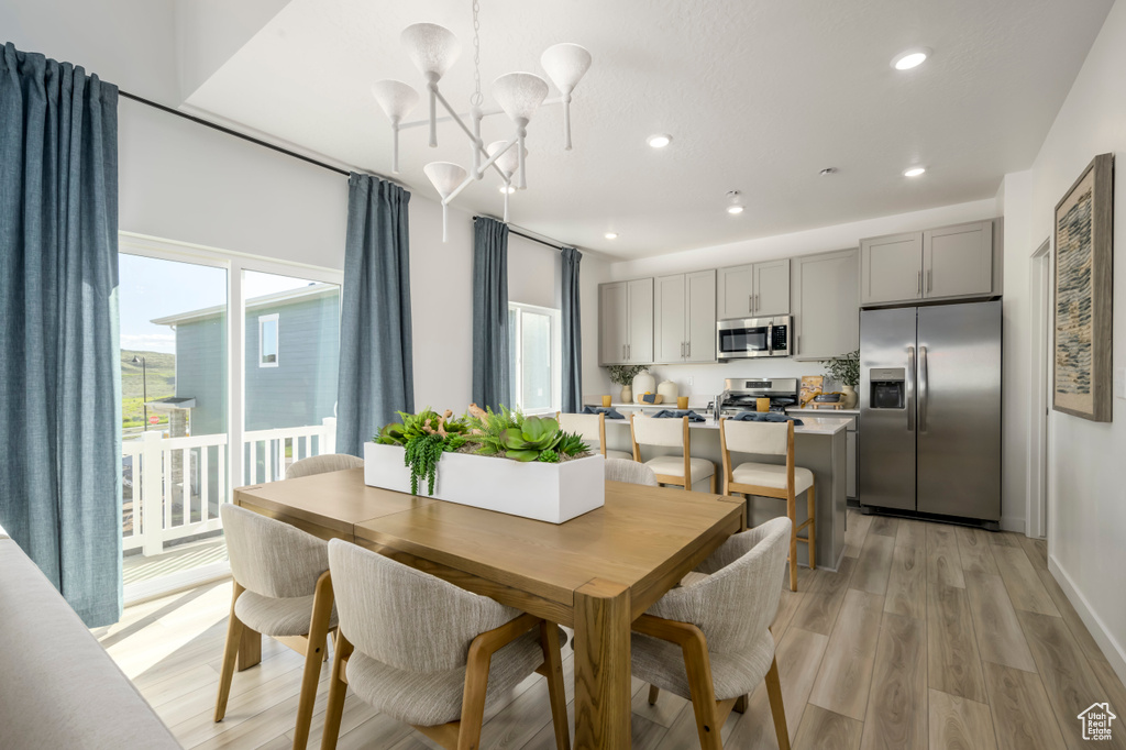 Dining area featuring light wood-style flooring, recessed lighting, and a chandelier