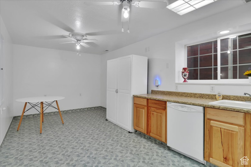 Kitchen featuring ceiling fan, a sink, white dishwasher, and light floors