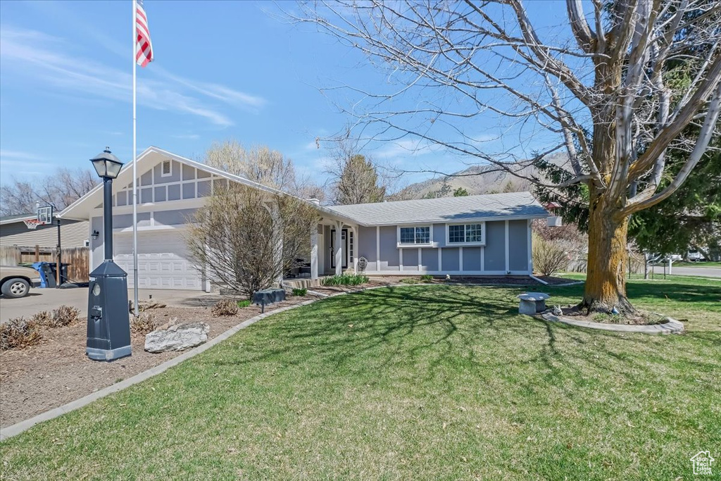 View of front of home featuring a front yard and a garage