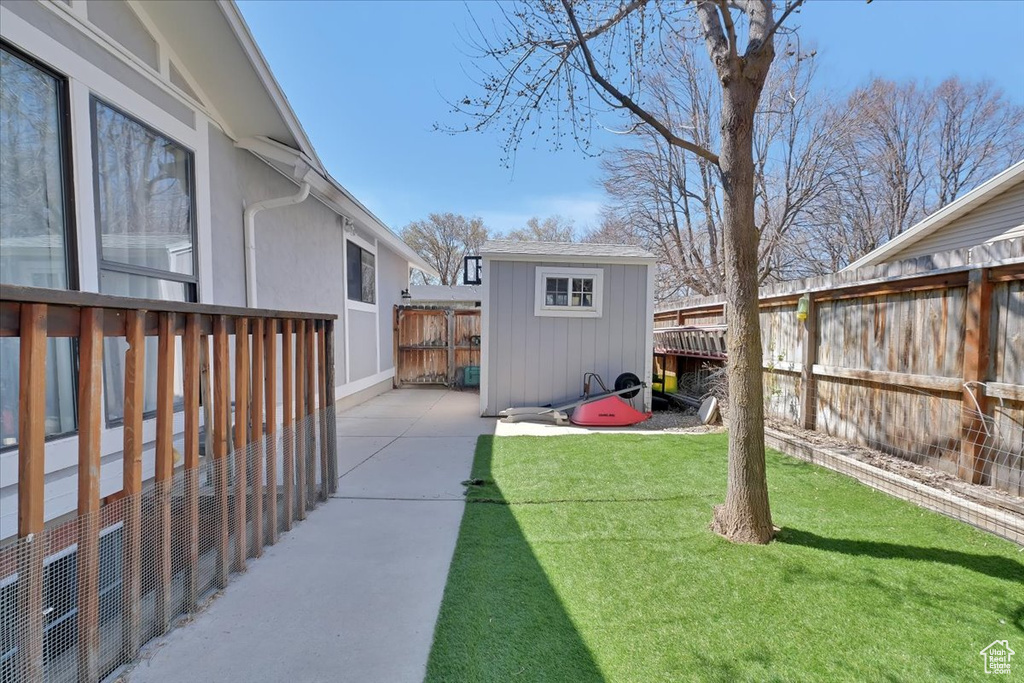 View of yard with a patio area, a fenced backyard, a shed, and an outdoor structure