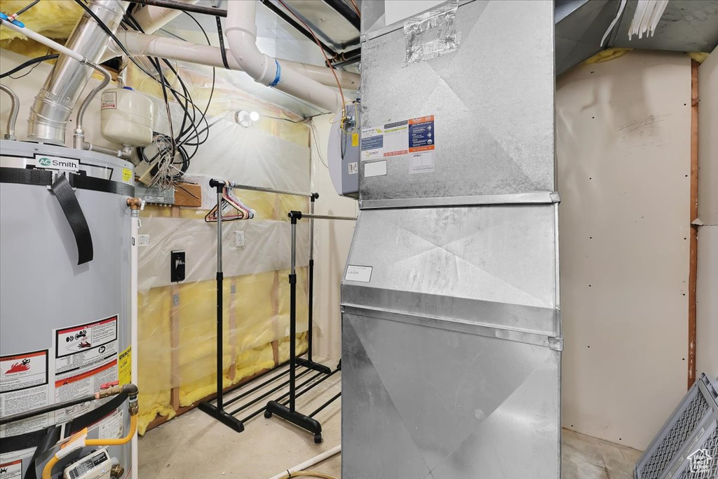 Utility room featuring visible vents and strapped water heater