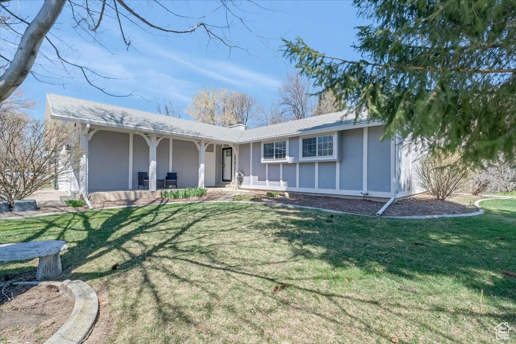 View of front of property featuring a front yard, a porch, and stucco siding