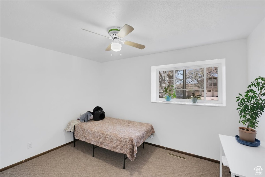 Bedroom featuring carpet flooring, baseboards, a ceiling fan, and visible vents