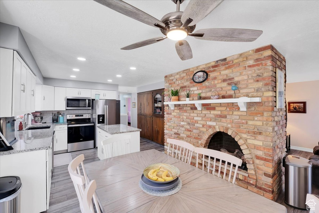 Dining area with light wood-style floors, a ceiling fan, and recessed lighting