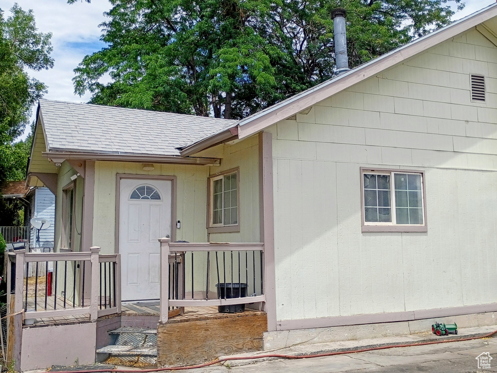 View of front of property with a chimney and a shingled roof