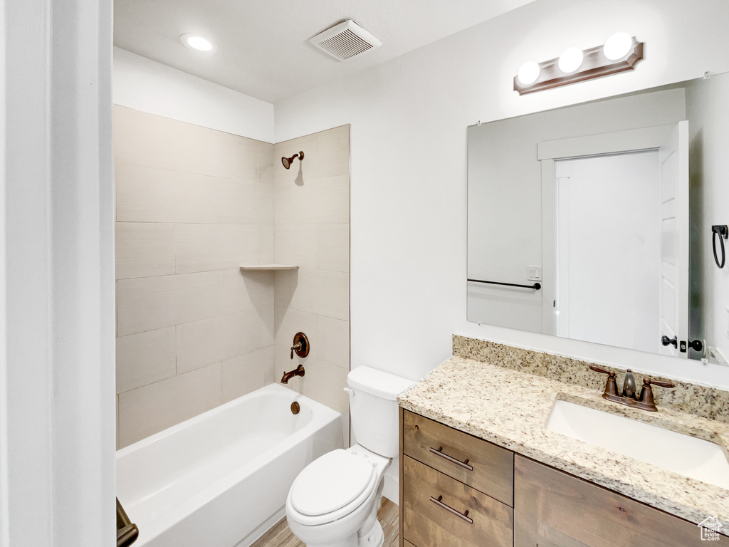 Full bath featuring visible vents, toilet, vanity, and shower / washtub combination