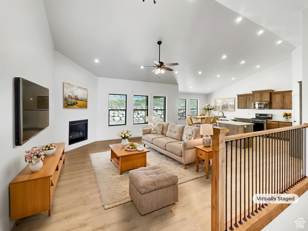 Living area featuring recessed lighting, ceiling fan, light wood finished floors, and a glass covered fireplace