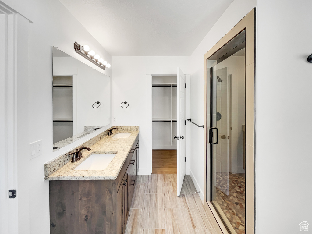 Bathroom with a sink, a spacious closet, and a stall shower