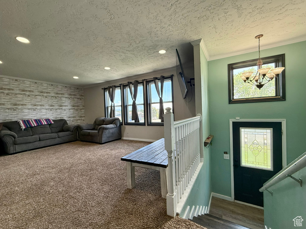 Living area featuring a chandelier, baseboards, a textured ceiling, recessed lighting, and carpet flooring