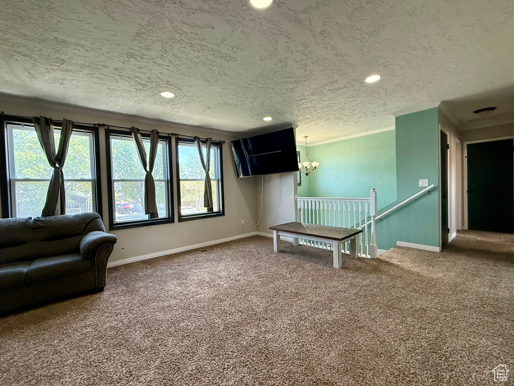 Sitting room featuring carpet floors, ornamental molding, a textured ceiling, recessed lighting, and an upstairs landing