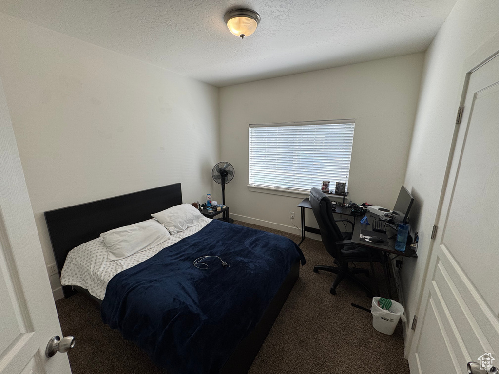 Bedroom with a textured ceiling and carpet
