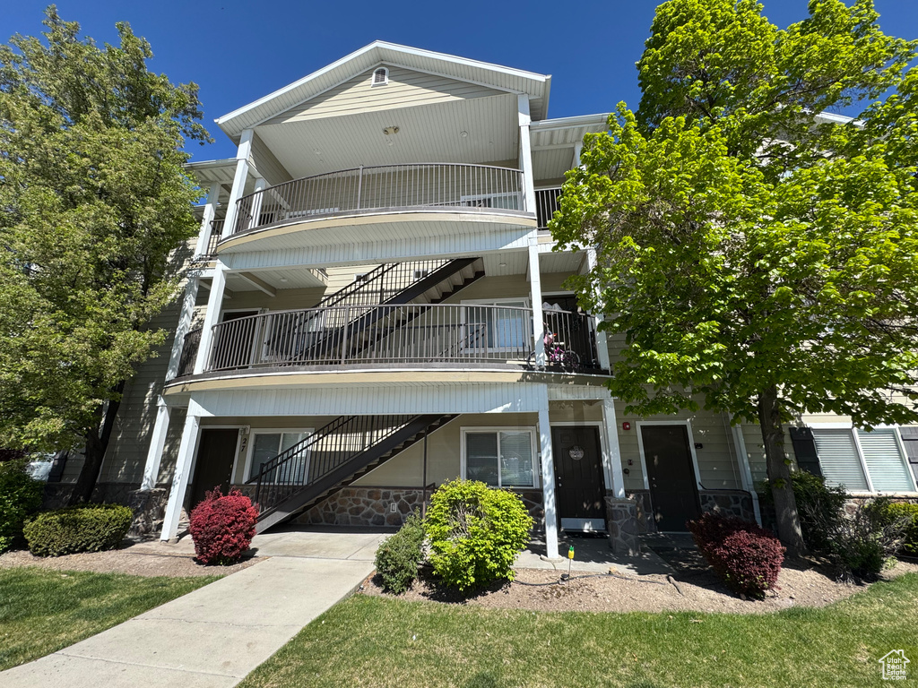 View of front of property with stairs and stone siding