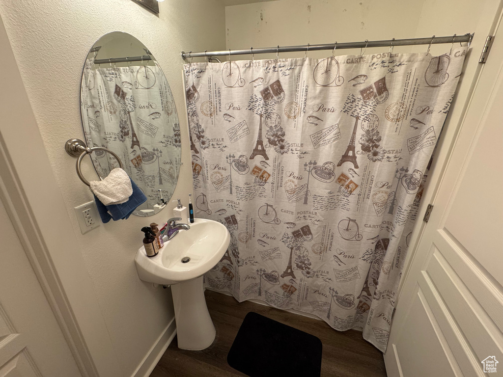 Bathroom with a shower with curtain and wood finished floors