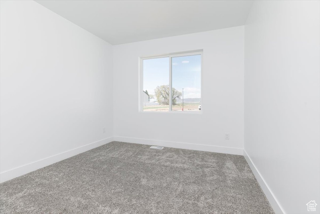 Carpeted empty room with baseboards