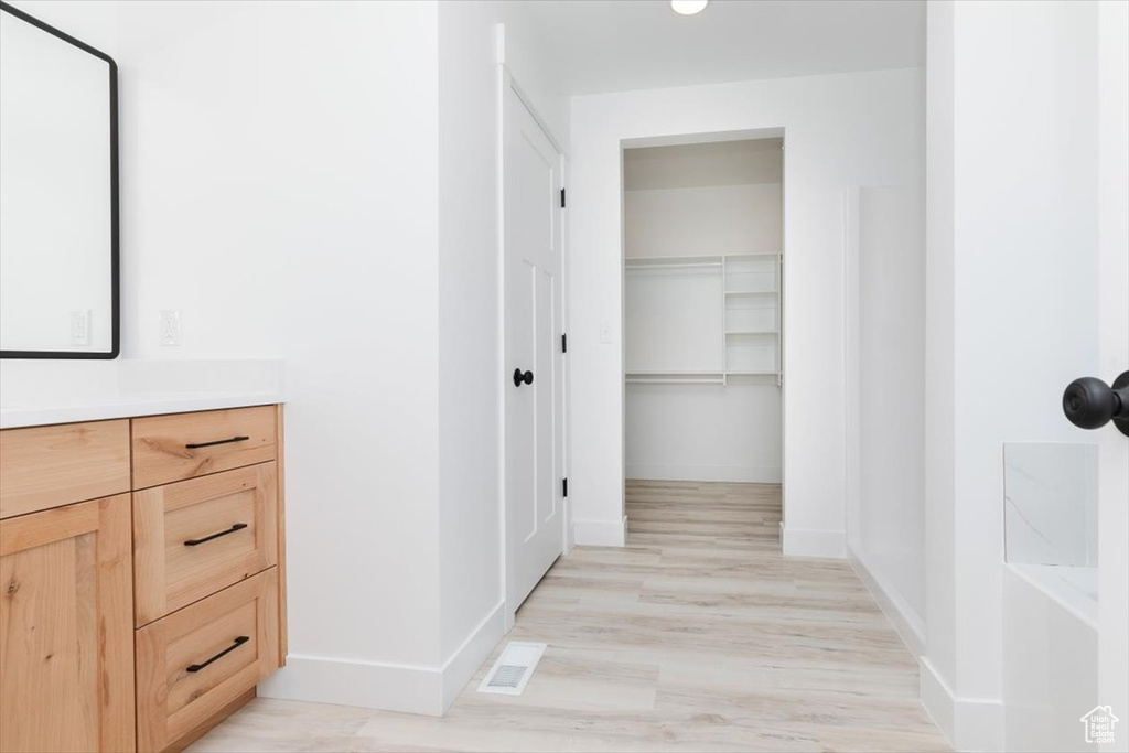 Full bath featuring visible vents, baseboards, wood finished floors, and vanity