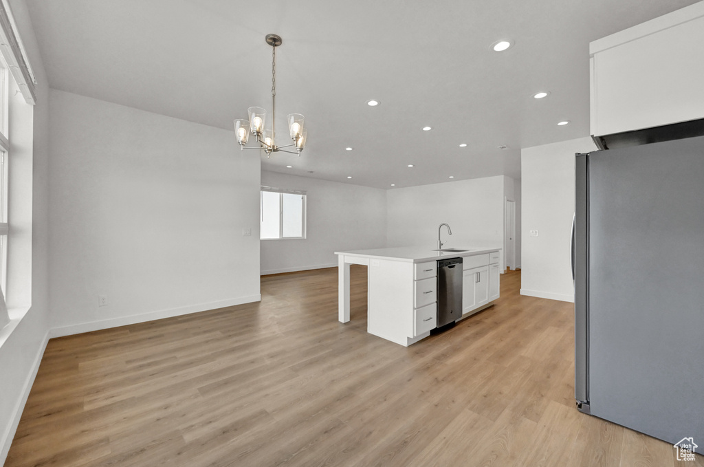 Kitchen with recessed lighting, open floor plan, white cabinetry, appliances with stainless steel finishes, and a sink