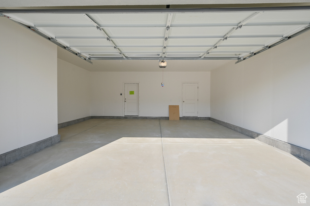 Garage with baseboards and a garage door opener