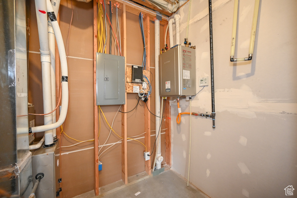 Utility room featuring electric panel and water heater
