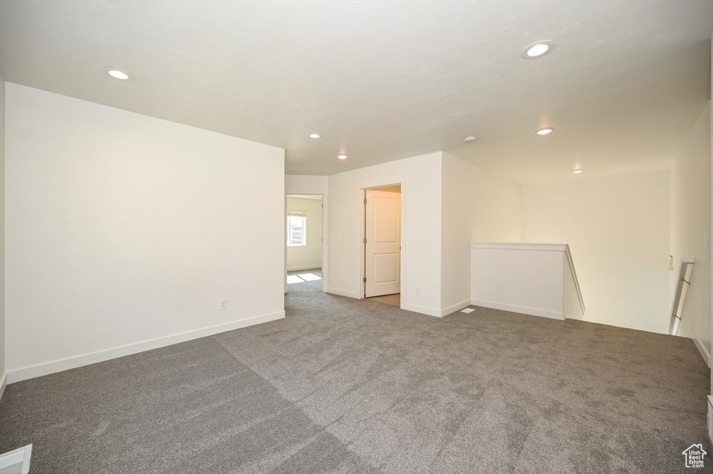 Carpeted spare room featuring visible vents, baseboards, and recessed lighting