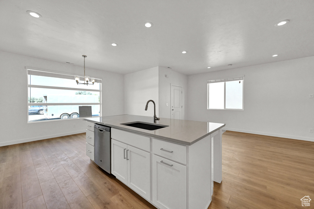 Kitchen featuring baseboards, white cabinets, a sink, recessed lighting, and stainless steel dishwasher