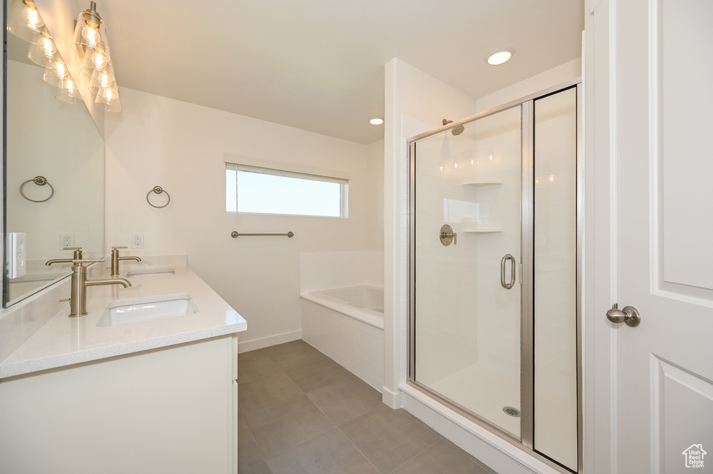 Full bath featuring a sink, a shower stall, double vanity, and a garden tub