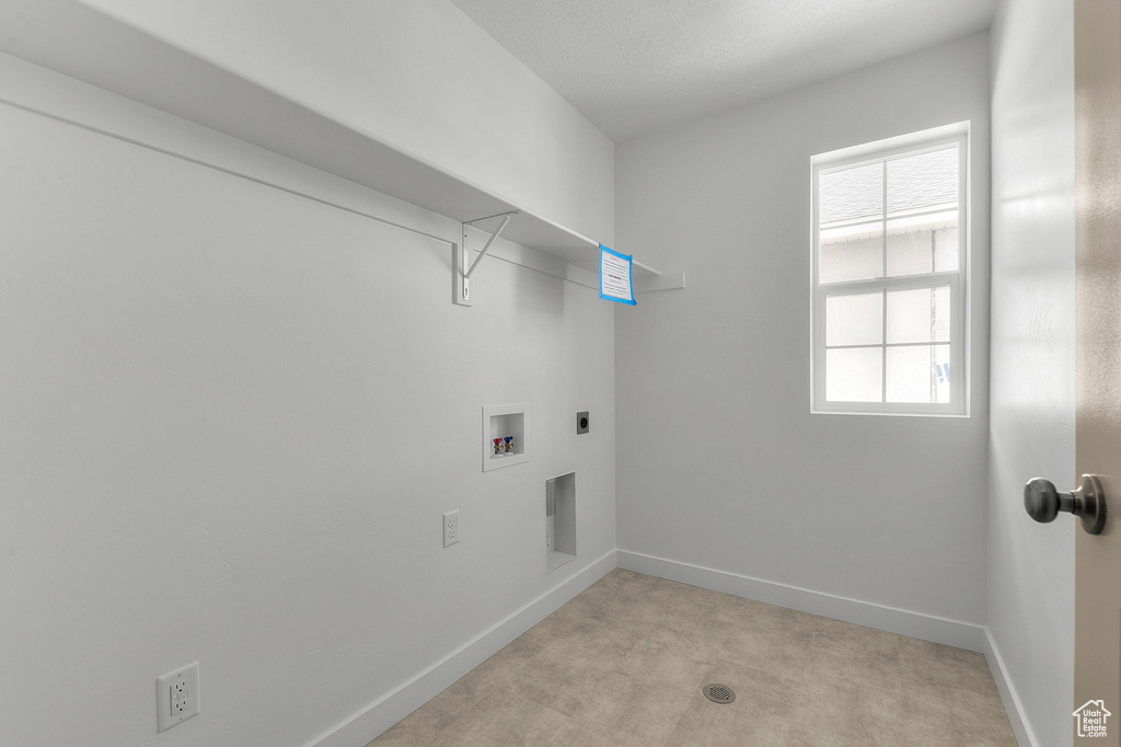 Washroom with baseboards, light colored carpet, washer hookup, and hookup for an electric dryer