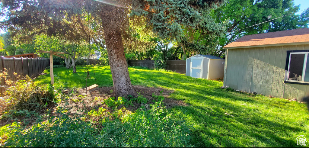 View of yard with an outbuilding, a fenced backyard, and a storage unit