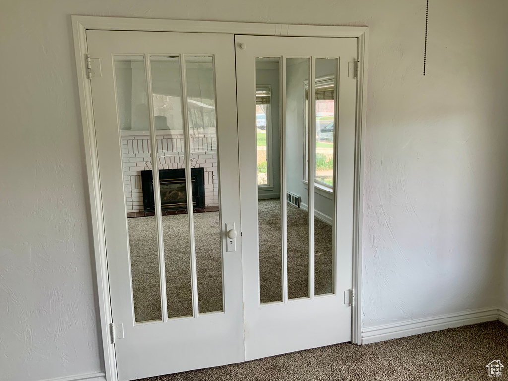Doorway with carpet flooring, a fireplace, and baseboards
