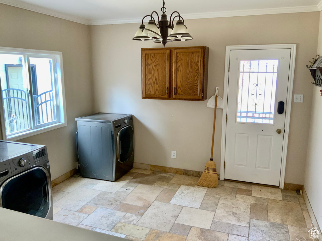 Laundry area featuring stone tile flooring, baseboards, plenty of natural light, and a chandelier