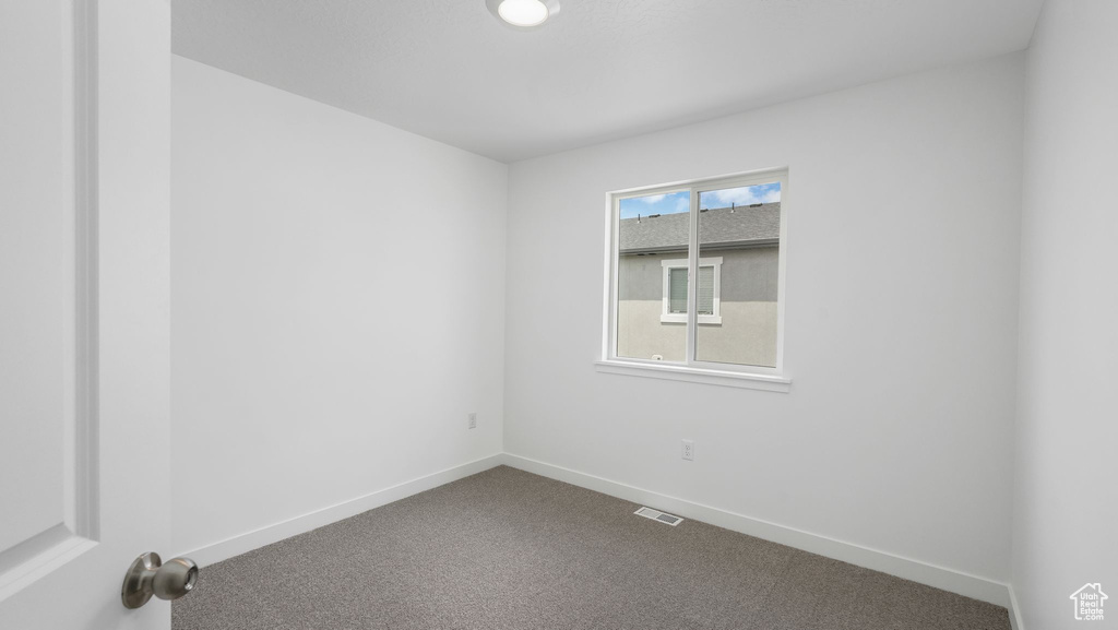 Carpeted empty room featuring baseboards