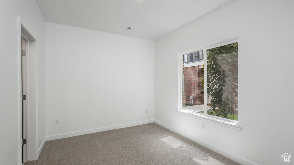 Carpeted spare room with baseboards