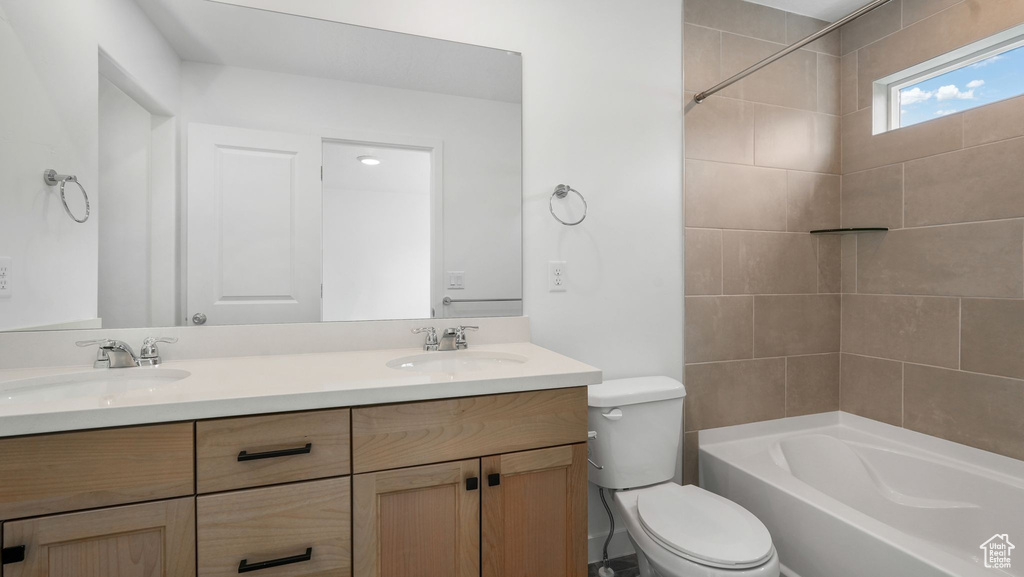 Full bath featuring double vanity and bathing tub / shower combination