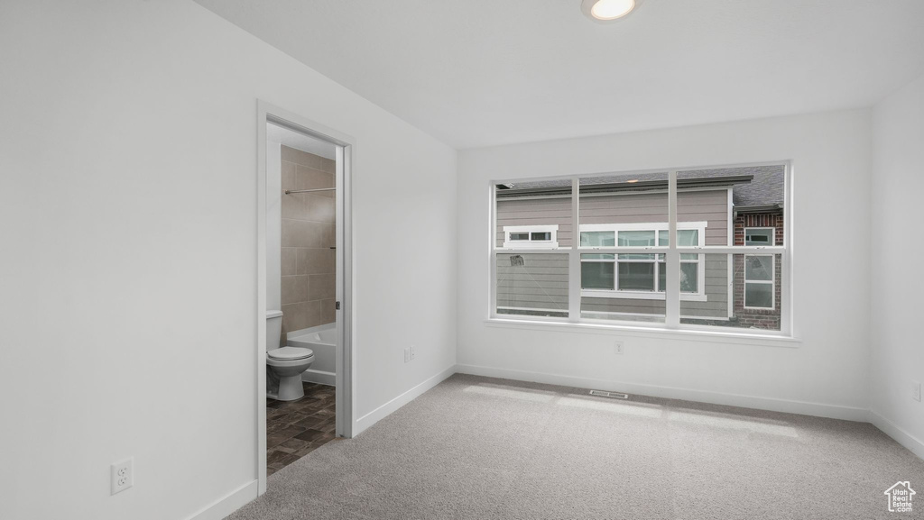 Unfurnished bedroom featuring carpet flooring and ensuite bathroom