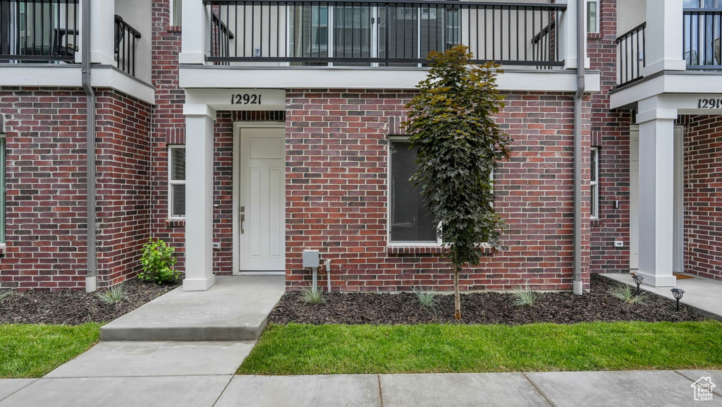 Entrance to property featuring brick siding and a balcony