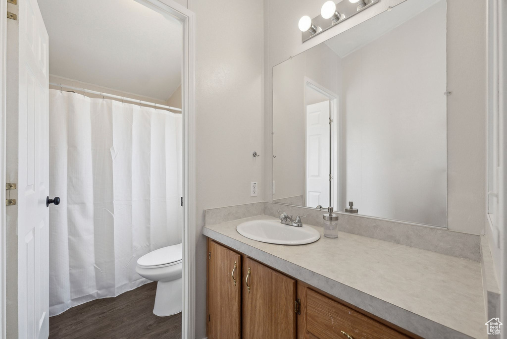Bathroom featuring toilet, wood finished floors, and vanity