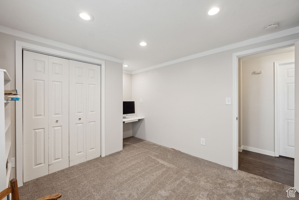 Unfurnished bedroom featuring recessed lighting, a closet, ornamental molding, and carpet floors