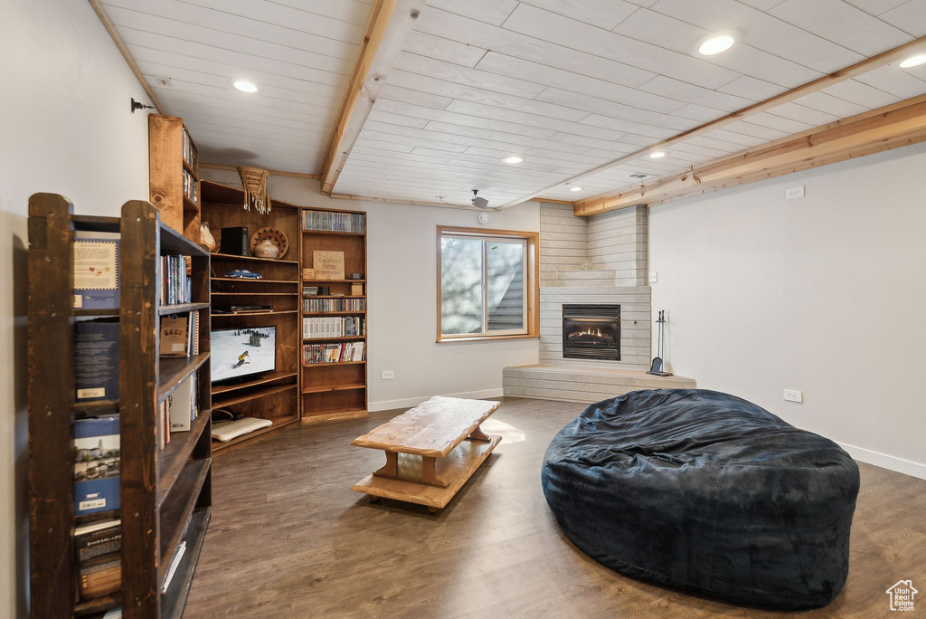 Living room featuring baseboards, recessed lighting, a brick fireplace, wood ceiling, and wood finished floors