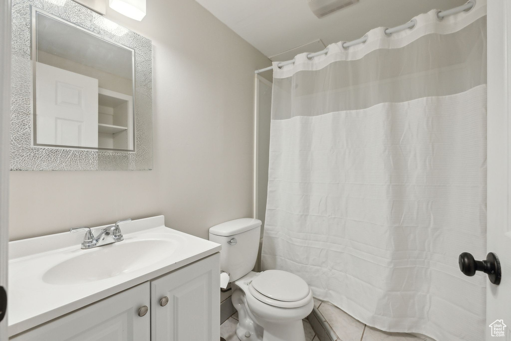 Bathroom with tile patterned flooring, toilet, curtained shower, and vanity