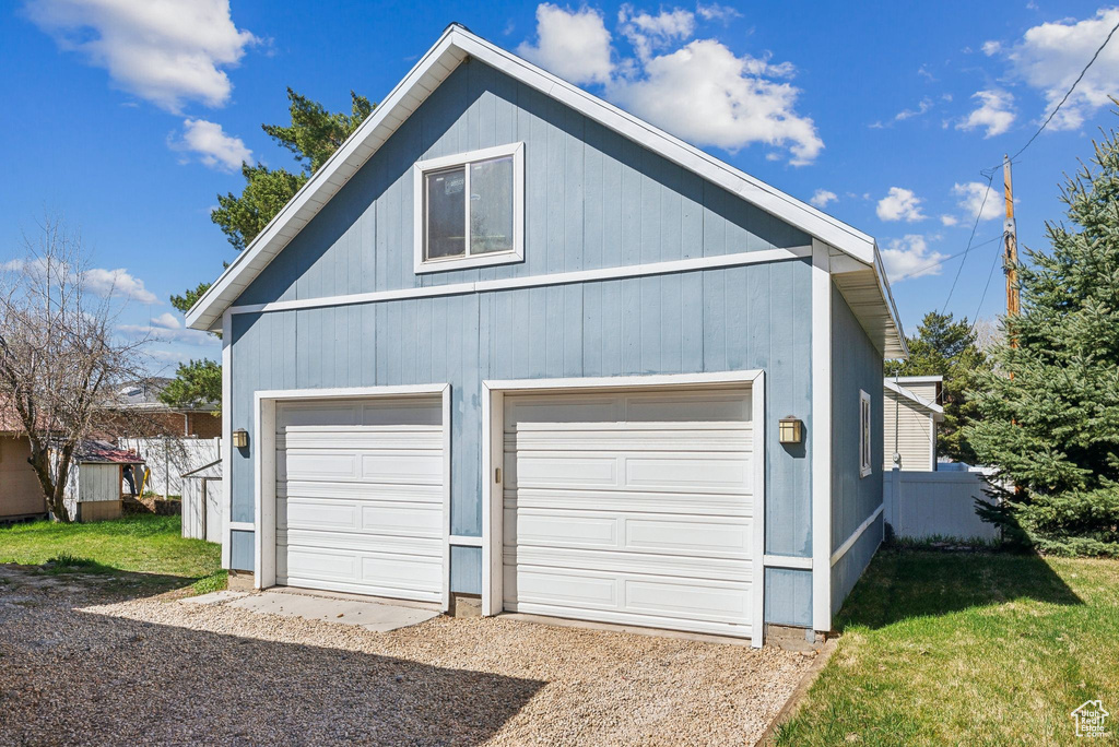 Garage featuring fence and a detached garage