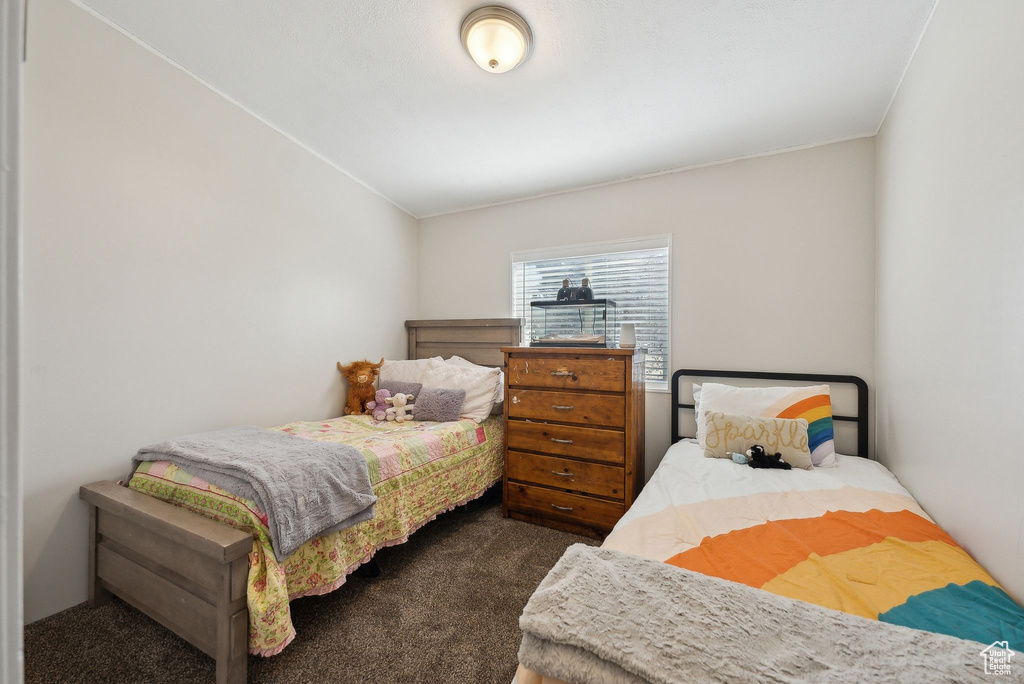 Bedroom with ornamental molding and dark carpet