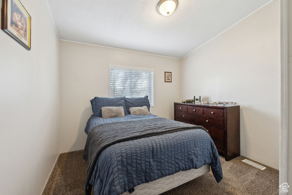 Carpeted bedroom featuring visible vents and ornamental molding