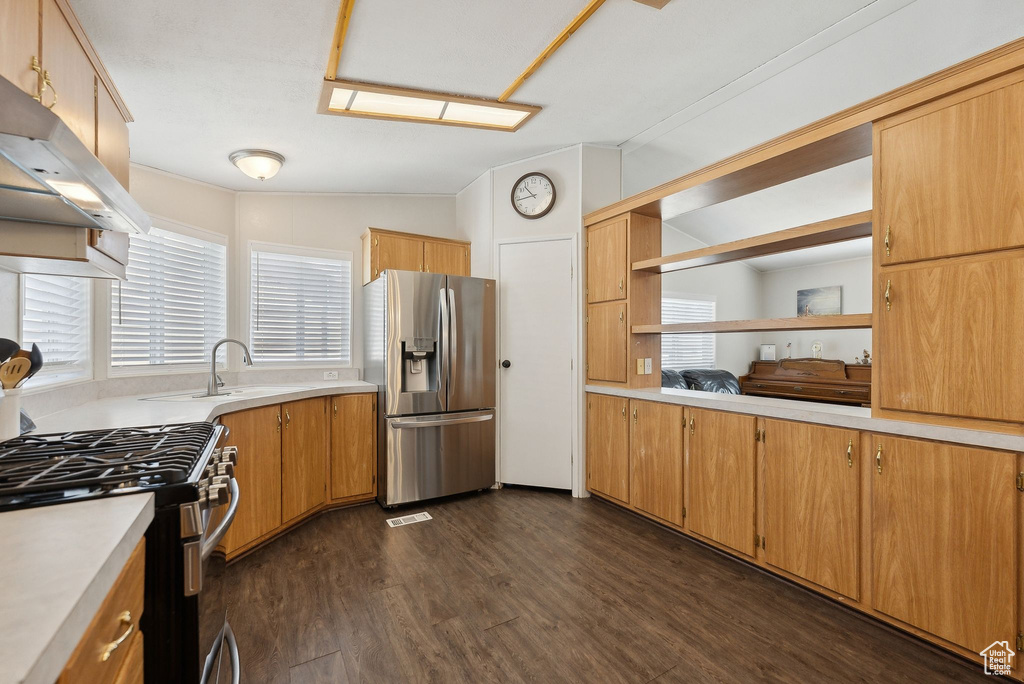 Kitchen featuring light countertops, open shelves, under cabinet range hood, stainless steel appliances, and a sink