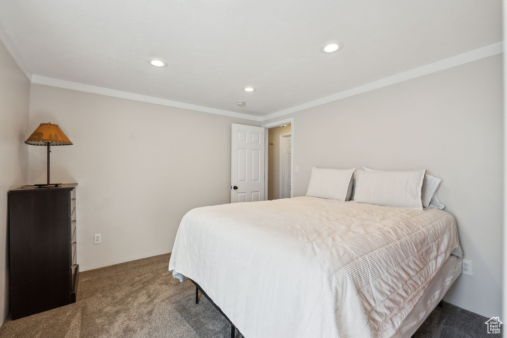 Carpeted bedroom with recessed lighting and crown molding