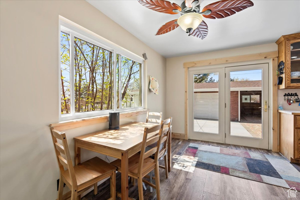 Dining area featuring wood finished floors, a ceiling fan, and a healthy amount of sunlight