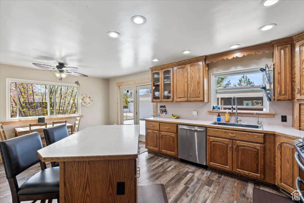 Kitchen featuring brown cabinets, a sink, a kitchen breakfast bar, and stainless steel appliances